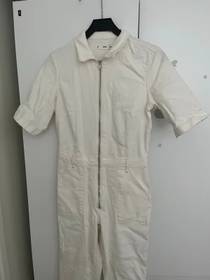 Vit jumpsuit med dragkedja från Mango - Helt ny jeans jumsuit endast testad, från mango! Så så snygg nu till sommarn men passar tyvärr inte mig därav säljer jag🙌💕stretchig så passar en S lika bra som en M