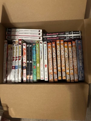 Samling manga: Attack on Titan m.fl. - Stor samling manga med bland annat flera volymer av Attack on Titan av Hajime Isayama, samt titlar som Re:Zero, highschool dxd, danganronpa 1 och danganronpa 2 goodbye despair och Platinum End. Böckerna har färgstarka omslag med manga- och animeillustrationer. Perfekt för dig som älskar japansk popkultur och spännande berättelser.