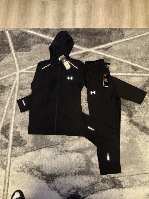 Svart träningsset från Under Armour - Helt ny och äkta tracksuit från Under Armour. Kvittot finns digitalt‼️ tracksuitet är helt ny med prislappen och oanvänd. Kan skickas samma dag🔥 priset kan diskuteras💯 först till kvarn som gäller. 