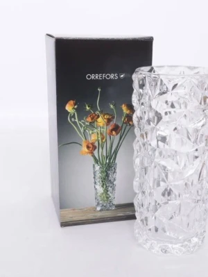 Orrefors kristallvas Carat Design Lena Bergström  - Säljer en stilren kristallvas från Orrefors med ett coolt, geometriskt mönster. Vasen är genomskinlig och har en cylinderformad design som reflekterar ljuset snyggt. Perfekt för att lyfta fram blommor eller som inredningsdetalj.
