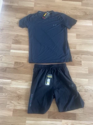 Svart träningsset från Under Armour - T-shirt i M och shorts i L. Helt ny