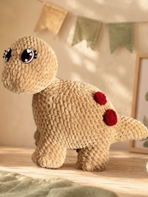 Mjuk dinosaurie gosedjur beige - Supergulligt beige dinosaurie gosedjur med stora filtögon och roströda prickar på ryggen. Tillverkad i mjukt, fluffigt garn som känns skönt att krama. Perfekt som dekoration eller mysig kompis i sängen.