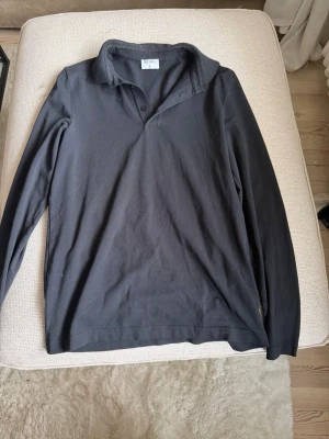 Svart långärmad piké Filippa K - Säljer en svart långärmad piké från Filippa K. Piken  har klassisk krage, knappar framtill och är tillverkad i mjuk bomull. Perfekt för en stilren och enkel look. Bra skick stretchigt material strlk xs/s. Pris går att diskutera