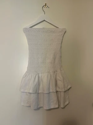 Vit sommarklänning, Gina Tricot - Supersöt vit sommarklänning från Gina Tricot i storlek XXS. Klänningen har smock upptill och volangig kjol med två lager. Inga fläckar eller liknande. Perfekt för varma dagar och enkel att styla med accessoarer. Tillverkad i mjuk bomull för en skön känsla. Den är perfekt till exempel midsommar☀️😻Pris gå alltid att diskutera🩷