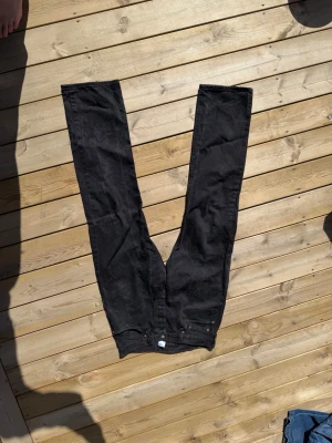 Svarta Levi's jeans W34 L34 - Säljer ett par svarta jeans från Levi's i 100% bomull. Klassisk rak passform med fem fickor och knappgylf. Perfekta för dig som gillar tidlös stil och vill ha ett par jeans som funkar till det mesta.