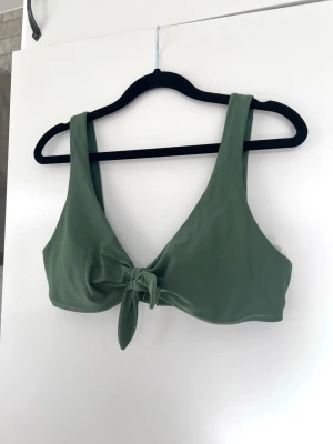 Olivgrön bikini från Hollister, stl M - En mörkgrön bikinitopp utan ilägg, från Hollister. Storlek M. Knappt använd.  Bystmått: ca 73cm 