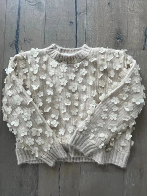 Beige stickad tröja med blommor Zara - Säljer denna söta stickade tröjan från Zara. Perfekt nu till våren/sommaren och passar bra med jeans och kjol☀️🌸💗