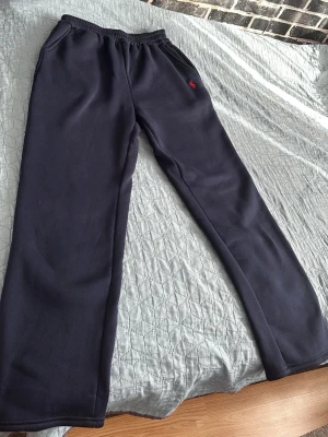 Ralph Lauren mjukisbyxor - Snygga mörkblå utsläppta mjukisbyxor från Polo Ralph Lauren med rakt ben och elastisk midja. Byxorna har fickor på sidorna och en liten röd logga broderad vid höften. 