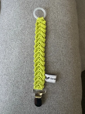 Virkad napphållare  - Virkad, limegrön napphållare, virkad av mig i 100% bomullsgarn med metallclip och silikonring.  Mönsterskapare: animo.design