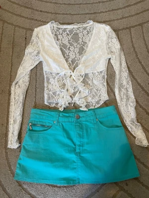 Kjol +topp❤️ - Säljer en vit, transparent spetsblus med långärmade ärmar och en turkos lågmidjad jeanskjol midjemått 36cm (stretchig) längd 29cm💕 Båda för 499💕