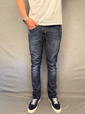 Nudie jeans grim tim - Säljer dessa sjukt feta nudie jeans med en galet bra passform! Size w30 L32. Skick 9/10 inga defekter. Midja: 40cm . Längd :100cm. Skriv vid frågor💯