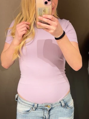 Ljuslila kortärmad body - Säljer då jag aldrig använt den då jag känner att lila inte är min färg.