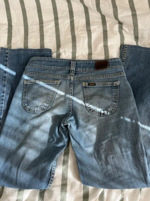  Lee jeans bootcut lågmidjade  - Jättefina jeans med snygg passform!! Köpt på vinted men passade inte, Inga defekter förutom slitningar längs ner på benen men inget man lägger märke till när man bär dem (sista bilden). Det är bara att ställa frågor om du undrar något!  Innerbenslängd: 72cm Midja: 36,5cm