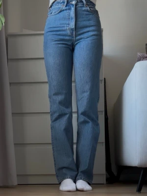 Blå raka high waist jeans WEEKDAY W26 L34 - Vill egentligen inte sälja för tycker att de är de mest PERFEKTA jeansen, men tyvärr är de för små för mig i midgan. Storleken är W26 L34. Säljer ett par klassiska blå jeans med hög midja och raka ben. Jeansen har fem fickor och stängs med dragkedja och knapp. Perfekta till vardagslooken och tillverkade i ett robust denimtyg.