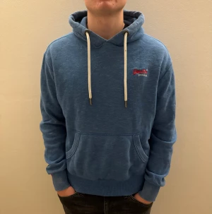 Superdry Hoodie - Säljer nu min super dry hoodie, as skön och kommer vara perfekt inför sena sommar kvällar, passar 170-180 cm. bra skick och ny pris 600-700kr priset är inte hugget i sten och det är bara att höra av sig vid frågor