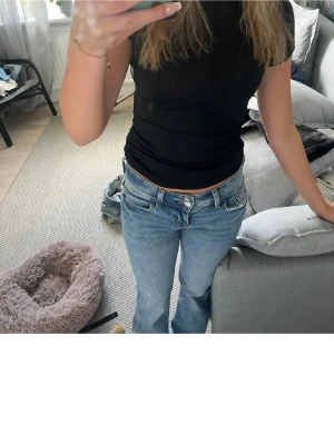 Blå bootcut jeans med detaljer - Säljer ett par lågmidjade ljusblå bootcut jeans med snygga broderade detaljer på bakfickorna dem är upptrampade nertil och köpta från plick💕