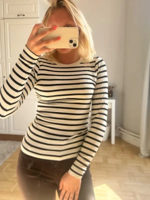 Randig långärmad tröja i vitt och svart💖💖🥺 - Säljer en snygg långärmad tröja med klassiska svarta och vita ränder. Tröjan har en rund halsringning och är figurnära i modellen. Perfekt för dig som gillar en enkel och stilren look.