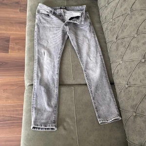 Grå jeans från Jack & Jones - Säljer ett par grå slim fit jeans från Jack & Jones i modellen Glenn. De har en snygg tvättad look och knappar i gylfen. Perfekta för både vardag och fest! 🖤