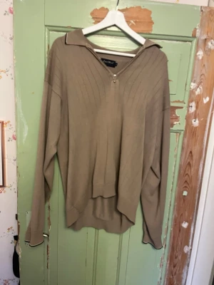 Beige stickad tröja med dragkedja - Snygg beige stickad tröja med halv dragkedja framtill och bred krage. Tröjan har långa ärmar, diskreta ribbade detaljer på axlarna och en avslappnad passform. Storlek L. Fråga gärna om bilder, priset kan alltid diskuteras!