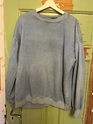 Ljusblå oversized sweatshirt - En enkel och stilren ljusblå sweatshirt med rund hals och ribbade muddar vid ärmslut och nederkant. Tröjan har en avslappnad, oversized passform och är tillverkad i mjukt bomullsmaterial. Perfekt för en chill och casual look. Storlek M. Fråga gärna om bilder, priset kan alltid diskuteras!