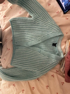 Turkos stickad kofta från lindex - Säljer denna söta kofta i fin turkos färg från Lindex! Storlek S endast använd en gång! 