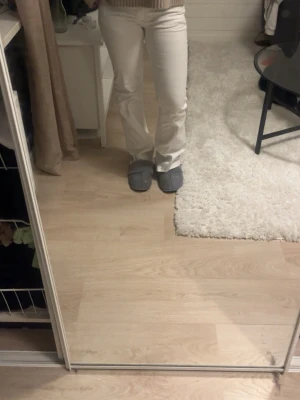 Vita bootcut jeans - Säljer ett par vita bootcut jeans med låg midja och klassisk femficksdesign. Jeansen har en snygg passform som sitter tajt upptill och släpper ut vid benen. Perfekta till en trendig vardagslook. Materialet känns som bomull med lite stretch.