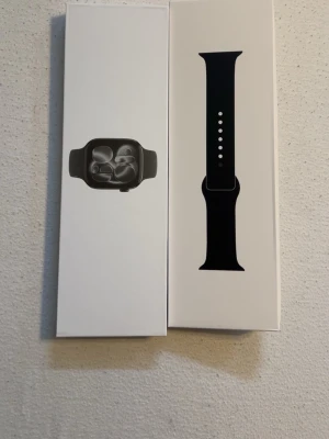 Apple Watch med svart sportarmband - Säljer en Apple Watch med svart sportarmband. Klockan har en stilren och modern design med rundade hörn och en svart silikonrem som är justerbar. Perfekt för dig som vill ha koll på träning, notiser och hälsa direkt på handleden.