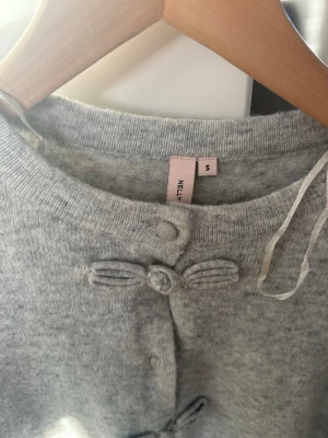 Stickad kofta  - Stickad kofta från Nelly. Aldrig använd men lappen är dessvärre ej kvar❣️ Ny pris 399 tror jag och går inte att köpa från deras hemsida. Skriv privat för frågor eller fler bilder tack😙fina detaljer på knapparna. 