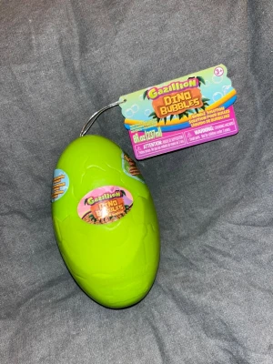 Såpbubbel ägg - Säljer en Gazillion Dino Bubbles bubbelflaska i form av ett grönt dinosaurieägg. Flaskan innehåller 237 ml såpbubbel vätska samt en liten dinosaurie.  Perfekt för lek utomhus och för alla som gillar dinosaurier och bubblor. Skapar stora och färgglada bubblor. Helt ny