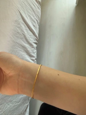 Guldigt armband från Caroline Svedbom - Guldigt armband från Caroline Svedbom med mörkgröna stenar på