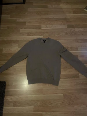 Beige stickad tröja från H&M - Säljer en stilren beige stickad tröja från H&M med regular fit. Tröjan har rund halsringning och ribbade muddar vid hals, ärmslut och nederkant. 