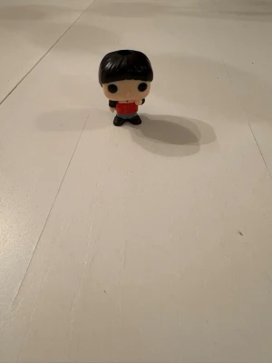 Will från stranger things - Säljer en Funko Pop vinylfigur med svart hår, röd tröja och blå byxor. Figuren har stora svarta ögon och typiskt stiliserat huvud. Perfekt för samlare eller som dekoration på skrivbordet.