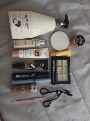 Sminkbas-kit med flera märken - Ett komplett sminkbas-kit med foundation, BB cream, concealerpalett, primer, puder, highlighter, ögonbrynsborste, pincett och lotion. Innehåller produkter från L'Oréal, W7, IsaDora, Maybelline, got2b och The Body Shop. Färgerna går i beige, nude och transparent.