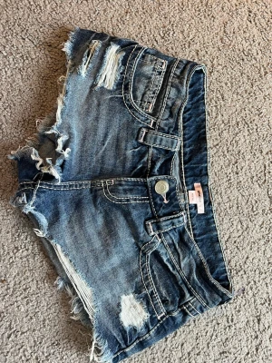 Blå slitna jeansshorts med fransar - Säljer ett par blå jeansshorts från Gina tricot i storlek xxs. Super fina men passar inte längre. Hör av er vid frågor och intresse ❤️