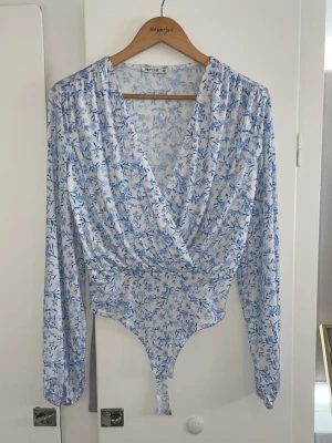 Blommig body från Nelly - En blommig omlottbody från Nelly i storlek XS. Jag säljer den för 200kr då den aldrig är använd, men är öppen för prisförslag <3