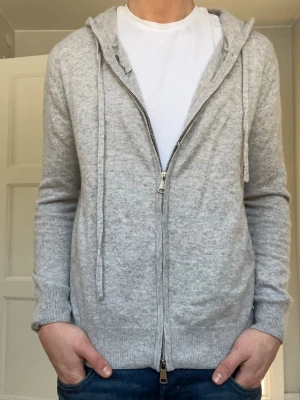 Ljusgrå zip hoodie med huva - Ljusgrå 100% cashmere zip, märke Venzo, säljs för att den är för liten, nästan helt ny använd 1-2 ggr Max, hör av dig vid frågor eller funderingar pris är diskuterbart!