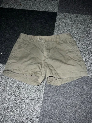Beiga shorts från Hampton Republic - Säljer ett par klassiska beiga shorts från Hampton Republic. De har normal passform, bälteshällor och sidofickor. Perfekta till sommaren och tillverkade i mjuk bomull för skön känsla hela dagen. Stl M men passar S