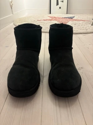 UGG CLASSIC MINI  - Säljer ett par svarta uggs i storlek 42. Dessa är äkta uggs och dom är i bra skick. Hör av dig vid frågor eller mer bilder.