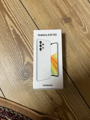 Samsung Galaxy A33 5G vit - Samsung Galaxy A33 5G i snygg vit färg. Telefonen har en modern design med rundade hörn, stor skärm och flera kameror på baksidan. Tillverkad i glas och plast, perfekt för dig som vill ha en snabb och stilren Android-mobil.