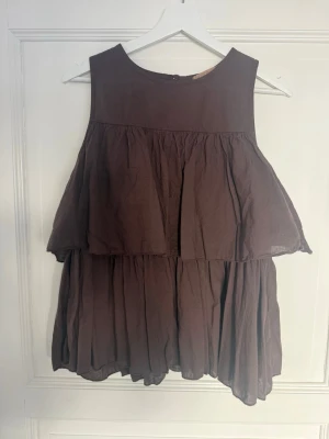 Brun volangtop - Säljer en brun, ärmlös topp med volanger och lös passform🤎