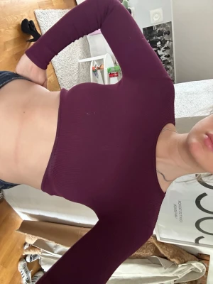 Zara Mörklila croppad ribbad topp M-L - Säljer en mörklila croppad topp med lång ärm och rund hals. Toppen är ribbad och har en tight passform som framhäver midjan. Perfekt att styla med höga jeans eller kjol.