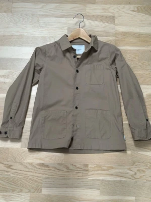 Les Deux Overshirt - Detta är en ljusbrun Les Deux Overshirt. Storleken på den är 146/152. Säljes pga att den är för liten! Bra skick, enda skavanker man finner på den är sömmar som gått upp (se sista bilden). Men det är inget man tänker på givetvis. Annars en jättesnygg och stilren Overshirt för dig med klass. Priset ej ristat i sten och det går jättebra att få ner det lite. Frågor??? Fråga!!!  Mvh Theo