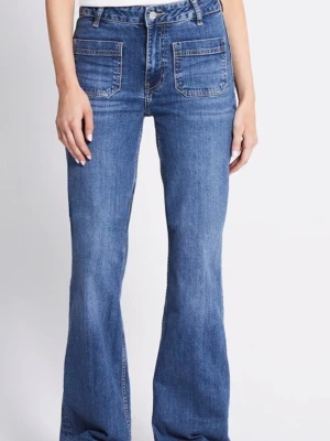 Blå bootcut jeans med fickor fram - Säljer ett par blå bootcut jeans med hög midja och stora fyrkantiga fickor fram. Jeansen har en klassisk denimlook och är tillverkade i bomull. Perfekta för dig som gillar en avslappnad men trendig stil.