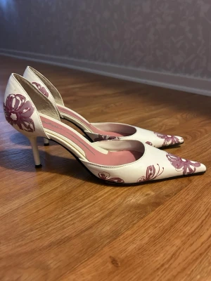 Vita klackar med blommor - Snygga vita pumps från Butterfly Twists med spetsig tå och smal klack. Köpta på Vinted men de va tyvärr för stora för mig. Skulle säga att de snarare är en storlek 39 än 38 då modellen är väldigt lång🩷klacken är 7cm🤭