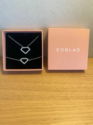 Smyckessett Edblad diamant form - Superfina halsband och armband från Edblad i silver. De har en diamant form med stenar runt om. Halsbandet är ca 44 cm långt och har inga defekter. Armbandet är ca 19 cm men har tyvärr tappat sitt edbladsmärke men är fortfarande fint! Säljs ihop men om man bara vill ha ett så skriv! Ask medföljer vid köp av båda. Hör av er vid frågor!💕