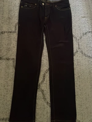 Mörkblå raka true religion jeans - Säljer ett par mörkblå jeans från true religion med raka ben och kontrastsömmar. Klassisk femficksmodell med snygga detaljer på fickorna och silverfärgade knappar. Tillverkade i USA, riktigt schysst denimkvalitet.