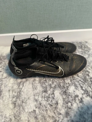 Nike Mercurial svarta fotbollsskor - säljer mina Nike Mercurial Vapor 14 Elite FG i färgställningen “Shadow Pack” stl 44,5 Skorna har snörning, låg profil och syntetiskt material för bra grepp och känsla på planen. Perfekta för dig som vill ha stilrena och snabba skor till matchen. påse finns om man vill ha med. 