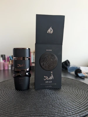Lattafa Asad Elixir (100 ml)  - Säljer Lattafa Asad Elixir (100 ml) i absolut nyskick med box, endast testsprayad. En extremt kraftfull och maskulin doft med grym prestanda som håller hela dagen. ​Doften påminner stilmässigt mycket om Boss Bottled Absolu med sin mörka, rika och exklusiva karaktär. Den öppnar med kryddiga noter av saffran och svartpeppar, för att sedan landa i en otroligt len, varm och krämig bas av vanilj, trä och bärnsten. Perfekt för höst, vinter och utekvällar för dig som vill ha en doft med tung karaktär!