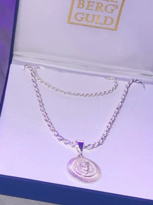 Silverhalsband med lejonberlock - Snyggt halsband i äkta silver (925) från Bergs Guld. Perfekt för dig som vill sticka ut med ett unikt smycke. Hänger ingår EJ 