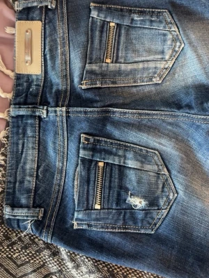 Vintage Jeans slitningar - Hej jag säljer mina vintage bootcut jeans ifrån stradivarius, dom är köpta på 90 talet då min mamma hade de när hon va ung. Dom är super low Waist och i storlek 32,  (Observera att dragkedjan har hoppat ur, men de är bara att sätta in den igen, se bild 6)pris kan diskuteras vid snabb affär! 